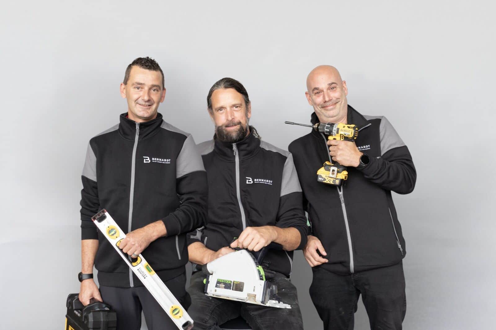 Drie handymannen van Bernardt VAD met waterpas, zaag en boormachine