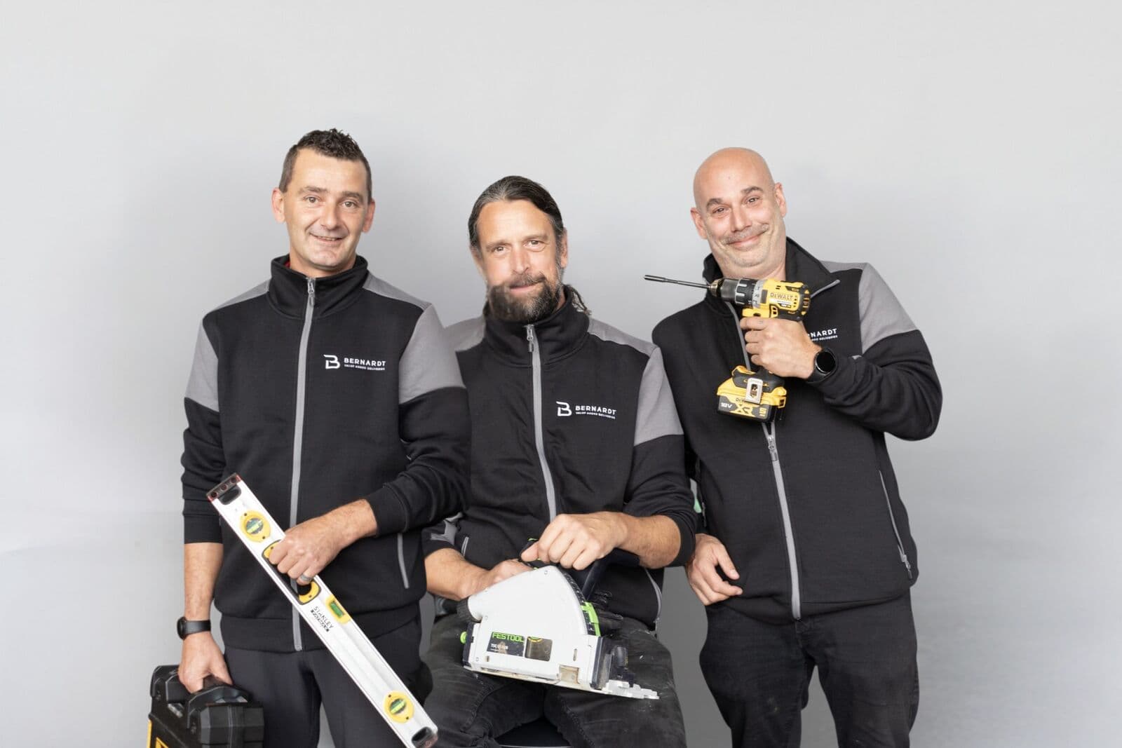 Drie handymannen van Bernardt VAD met waterpas, zaag en boormachine